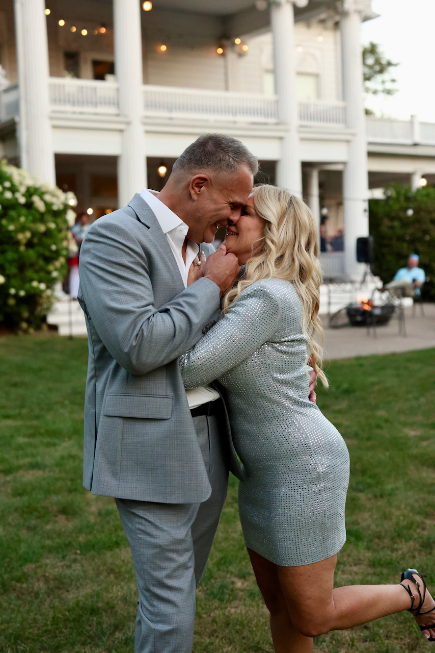 Ruby and DJ leaning toward each other and laughing, dressed for an evening out